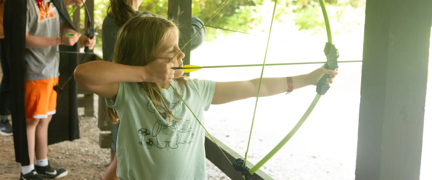 A girl doing archery at Camp