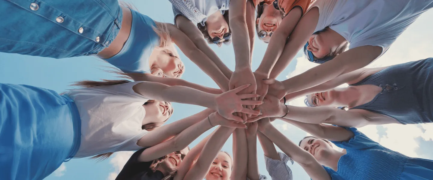 A group of people with their hands in together
