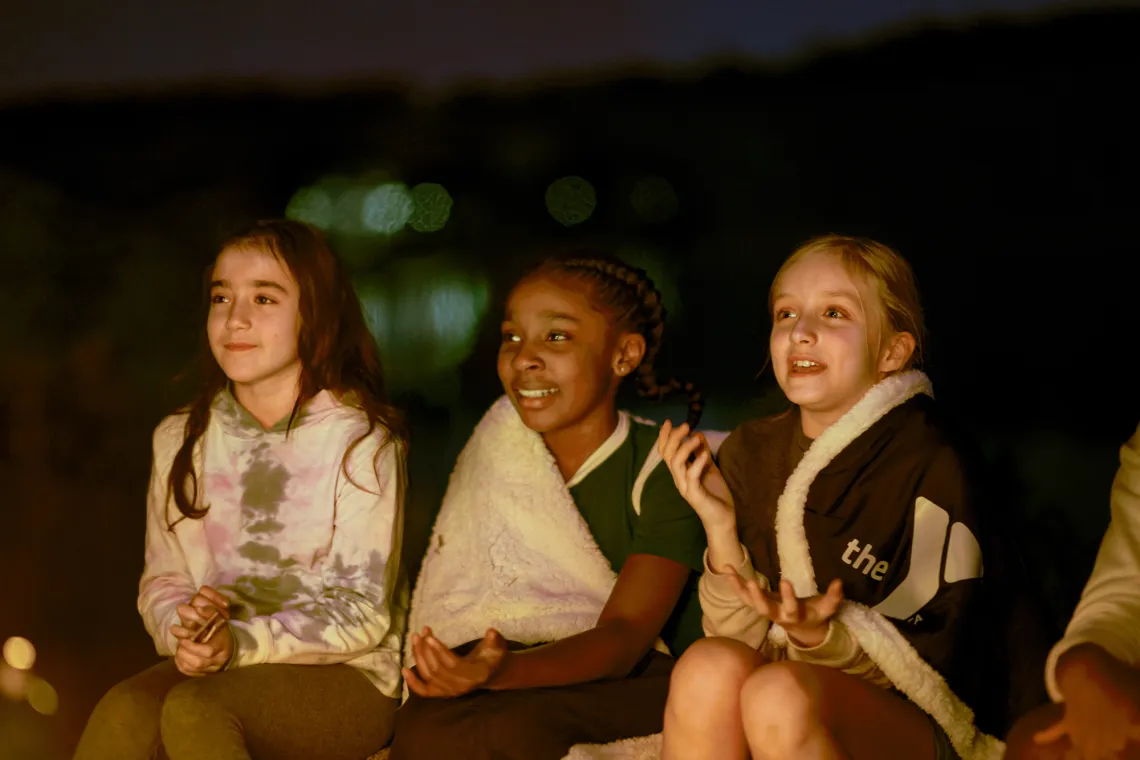 girls by a camp fire