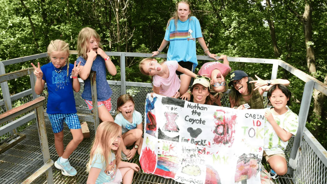 A group of kids at camp with their camp flag